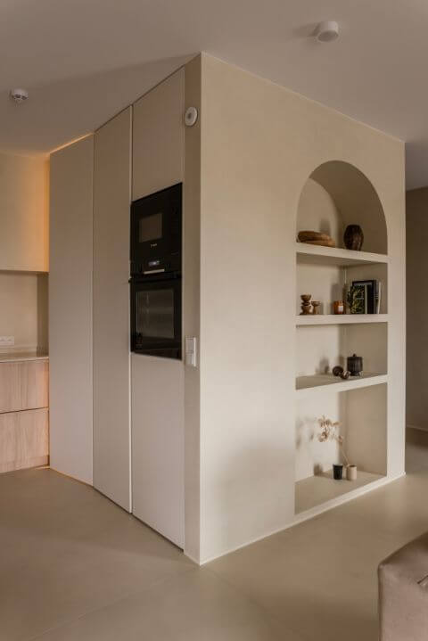 wnęka w kształcie łuku z półkami na książki i dekoracyjne przedmioty