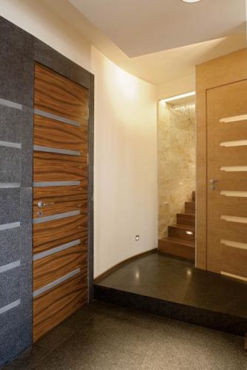 Architekci zaprojektowali nawet drzwi- drewniane z granitowymi paskami. Wstawki nawiązują do kamienia na podłodze.
