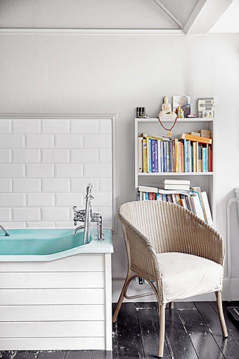 Ciekawa obudowa wanny - kafelki na ścianie i deski ceramiczne wokół wanny.