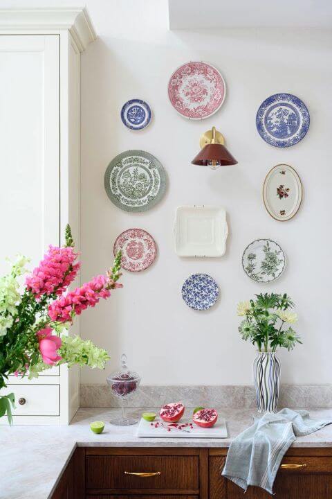 kolekcja porcelanowych talerzy na ścianie w kuchni