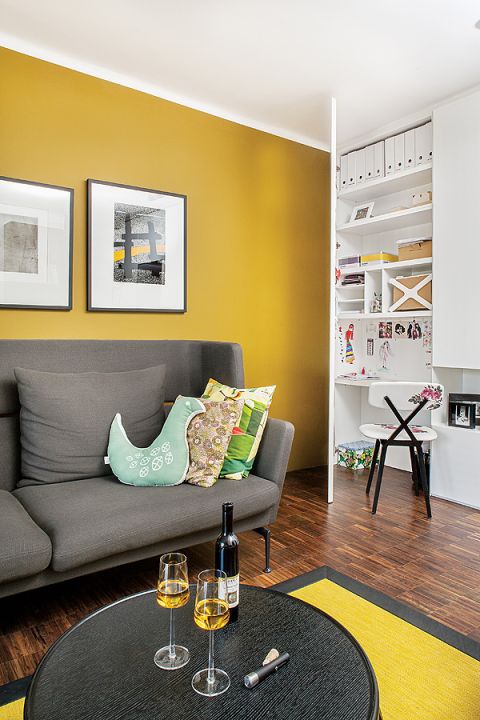 Ciepły palisandrowy parkiet i miodowa ściana. Do tego dizajnerskie meble. Sofa z Vitry, lampa marki