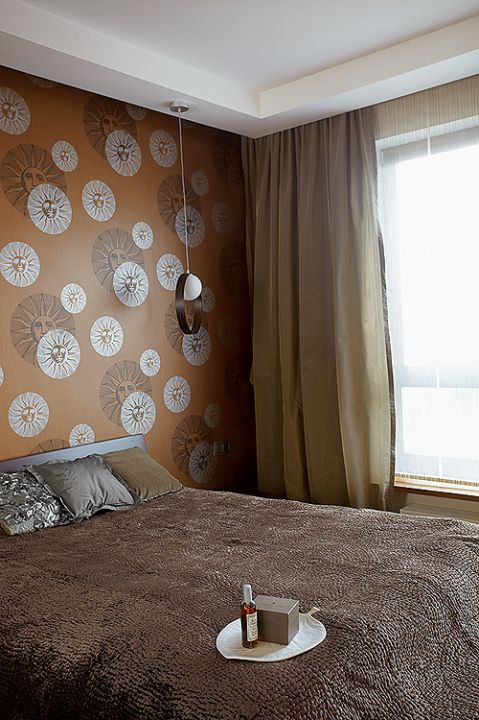 Dizajnerski nastrój w sypialni: tapeta Fornasetti Il Sole od Cole Son. Wisząca lampę zaprojektował Itre Giuko.