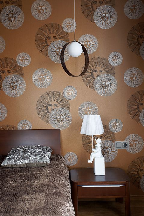 Dizajnerski nastrój w sypialni: tapeta Fornasetti Il Sole od Cole Son. Wisząca lampę zaprojektował Itre Giuko, a tę