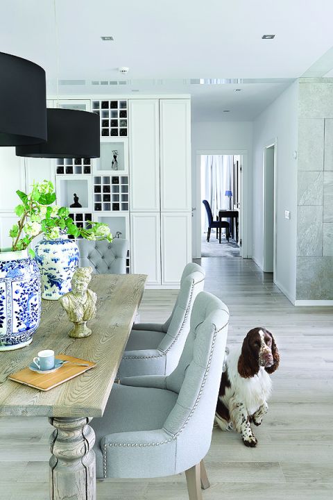 Do dużego masywnego stołu od firmy Jadik pasują fotele ze srebrnymi uchwytami z Decolor i kobaltowe wazony od Casa Mia.