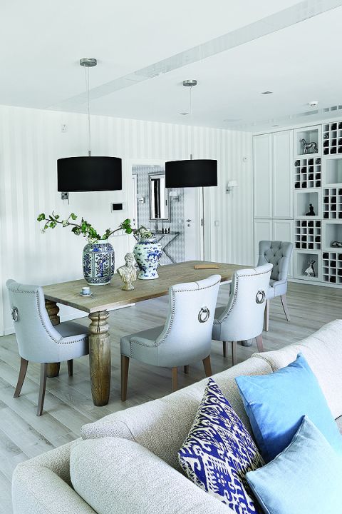 Do dużego masywnego stołu od firmy Jadik pasują fotele ze srebrnymi uchwytami z Decolor i kobaltowe wazony od Casa Mia.