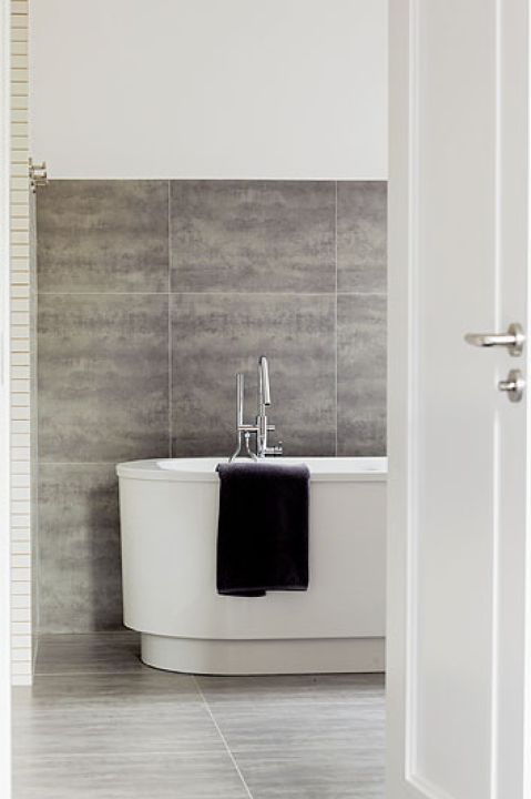 Duże, matowe płytki imitujące beton. To bardzo praktyczne rozwiązanie, bo kropelki wody są na nich praktycznie niewidoczne.