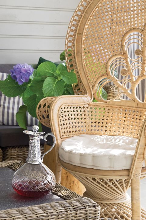 Królem foteli na werandzie jest finezyjnie pleciony paw, kupiony na Westwingu. Letni salon w południe