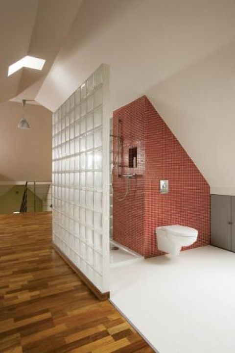 Łazienka oddzielona ścianą z luksferów.