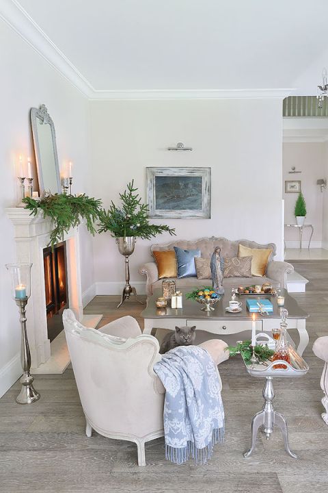 Na kominku prosty, ale efektownie wyglądający stroik z gałązek świerkowych.