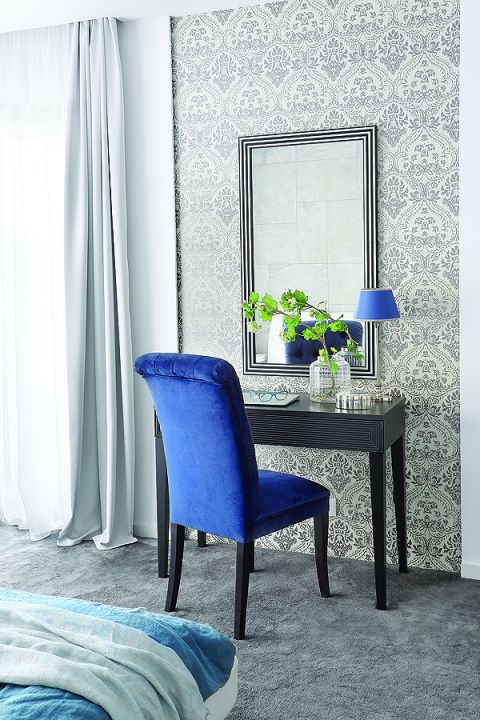 Na tle szaro-błękitnych ścian dominuje mocno niebieskie krzesło.