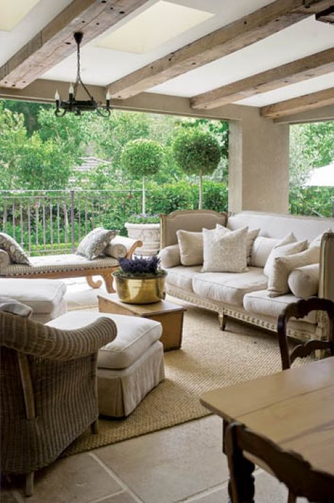 Na werandzie stoją plecione wiklinowe meble.