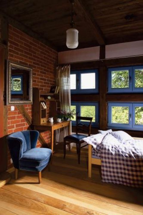 Niebieskie ramy okienne kontrastują z ceglanym murem.