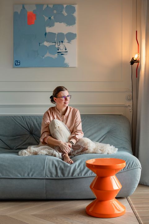 salon z pastelowoniebieską sofą i pomarańczowym stolikiem kawowym