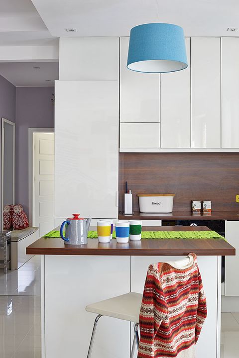 Proste białe fronty szafek bez przeszkleń - takie meble pomagają utrzymać porządek w małej kuchni.