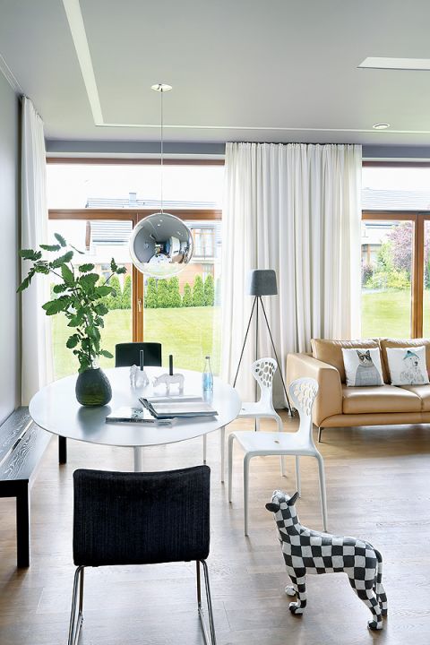 Stół Tulip i krzesła Supernatural. Czarny wazon i świeczniki z Bo Concept.