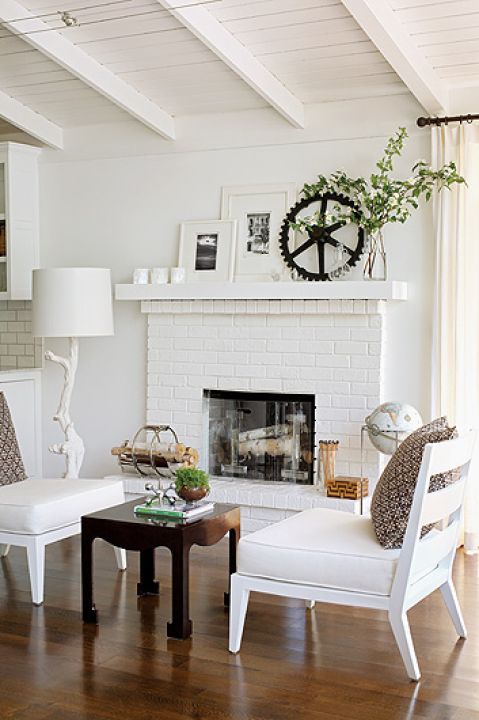 Subtelna zabawa dodatkami: na gzymsie kominka szklane ptaszki vintage i koło zębate.