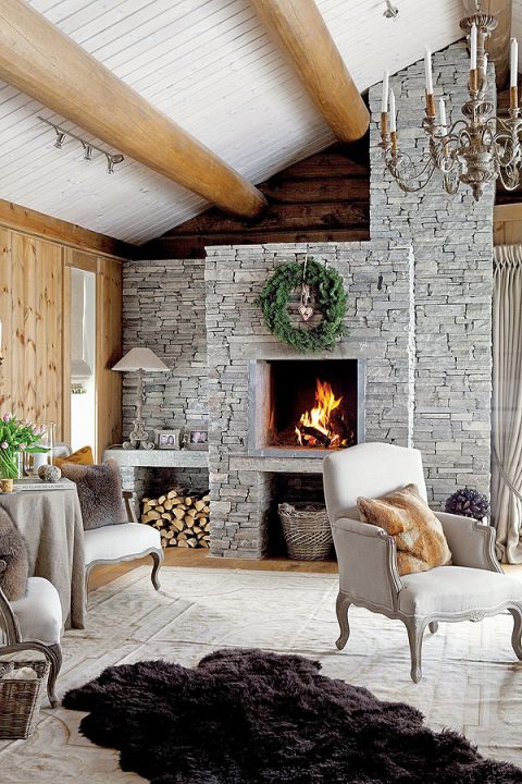 Surowe ściany z drewna i szary, kamienny kominek podgrzano finezyjnym detalem.