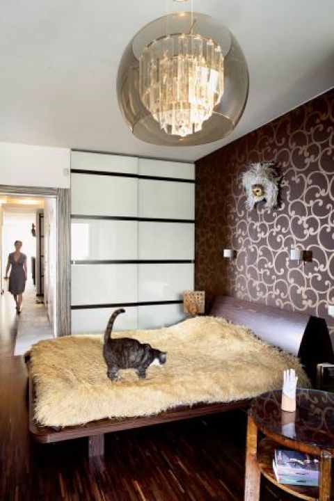 W sypialni drewniane łóżko i stolik.