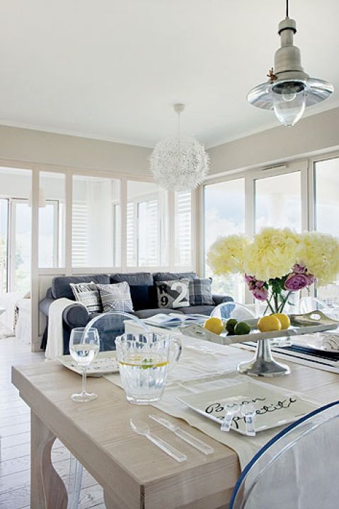 Wszędobylską biel przełamuje szara kanapa. Poduchy są od Decolor i Riviery Maison.