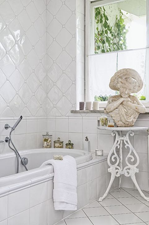 Białe, hiszpańskie kafelki. Na stoliku XIX-wieczna rzeźba z kolekcji Małgosi i Pawła.