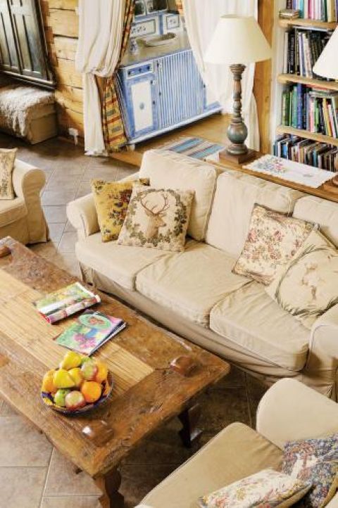 W salonie obok drewnianego stolika kanapa i fotele.