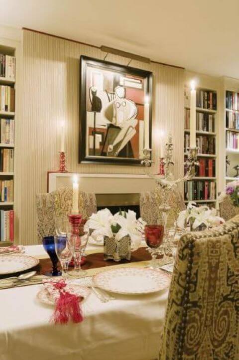 Wiktoriańska jadalnia w nowym wydaniu- wzorzyste tkaniny na stylowych krzesłach oraz współczesne malarstwo i półki