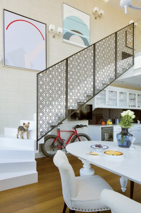 Ozdobą prostych dębowych schodów pomalowanych na biało jest ażurowa balustrada cięta laserowo z blachy. Jej