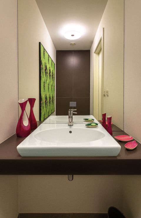 W toalecie gościnnej porcelana z Chodzieży i Ćmielowa, wzory z lat 60. oraz oprawiona w ramy kolorowa tkanina Łaźnia