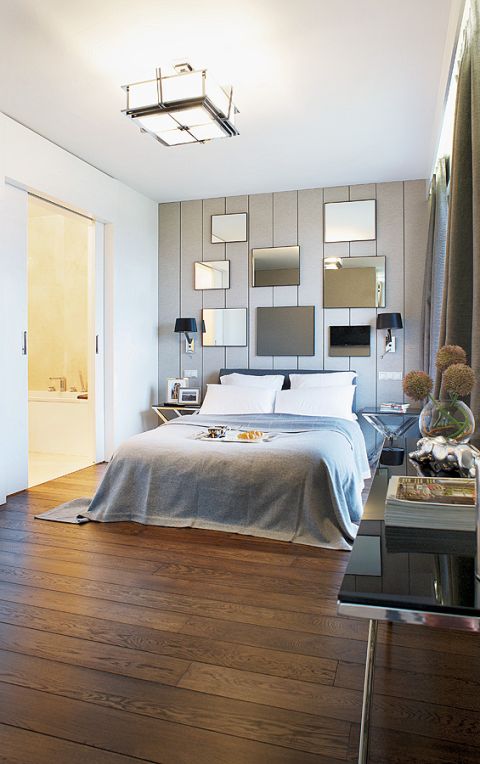 Największe wrażenie w sypialni robi ściana z lustrami. Łóżko ze sklepu NAP. Garderobę zaprojetowała pracownia