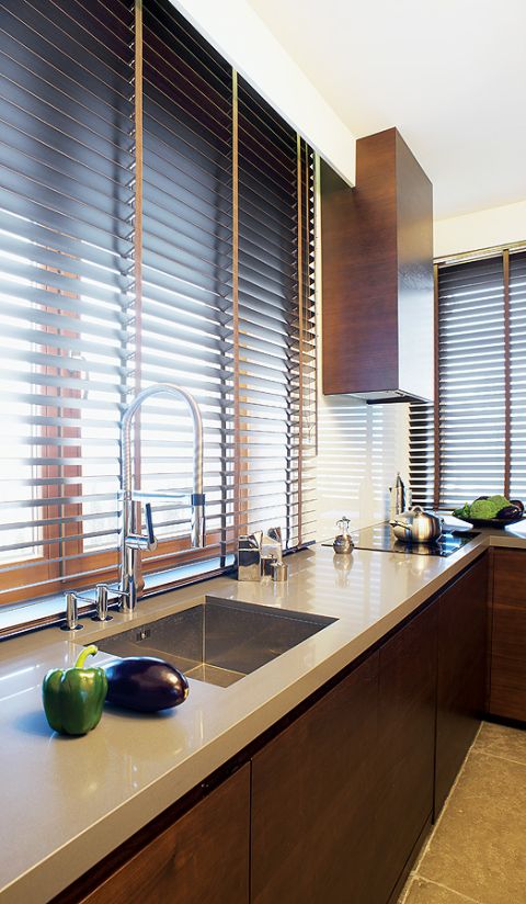 Minimalistyczna kuchnia stała się przytulniejsza dzięki kolorom, czekoladowym brązom i odcieniom cafe latte.