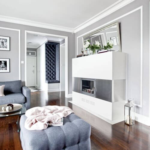 Nowoczesny kominek obłożony ciepłym i miłym w dotyku corianem.