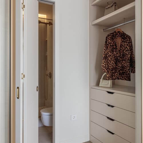 garderoba z zabudową na wymiar w jasnym kolorze w nowoczesnym apartamencie w paryskim stylu