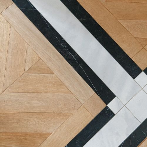drewniany parkiet połączony z czarno-białymi płytkami ceramicznymi