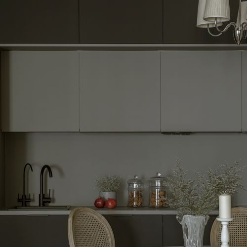 czarna kuchnia z górnymi szarymi szafkami