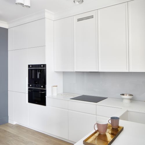 Czasem warto pójść na kompromis. W kuchni górne szafki zostały ozdobione klasycznymi frezami, pozostałe mają