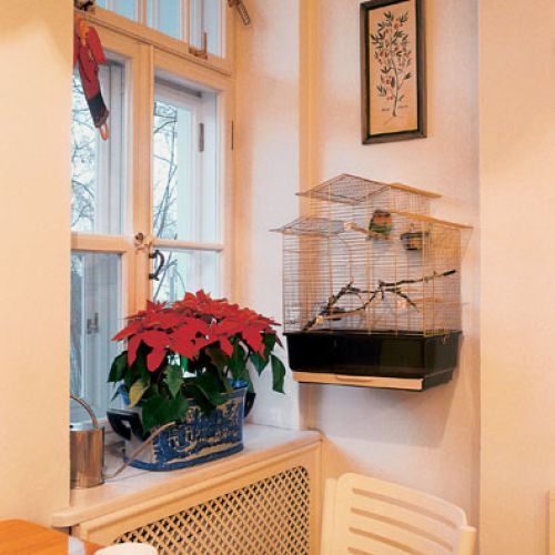 Architektoniczne detale przedwojennego domu podkreślają rustykalny chrakter wnętrza. Biale współczesne krzesła zupełnie przy