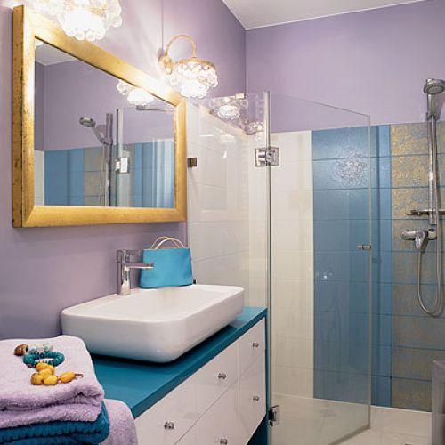 Barokowe kafelki, lustro w złotej ramie i kinkiety z kryształkami.