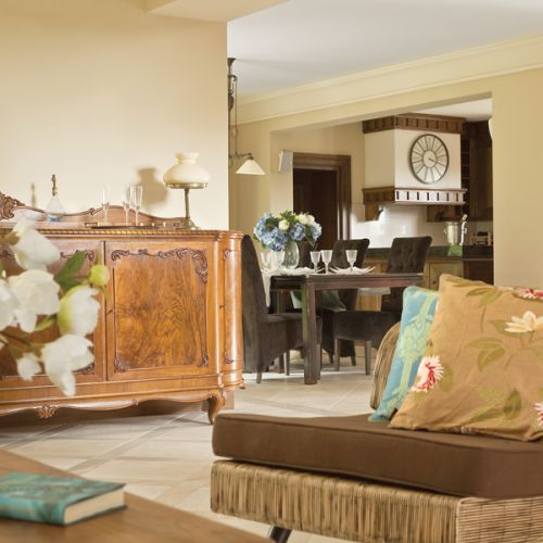 Beże i brązy, solidne dębowe meble i obraz z zabytkowym sportowym samochodem. Klasyka w najlepszym stylu.