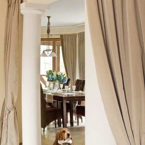 Beże i brązy, solidne dębowe meble i obraz z zabytkowym sportowym samochodem. Klasyka w najlepszym stylu.