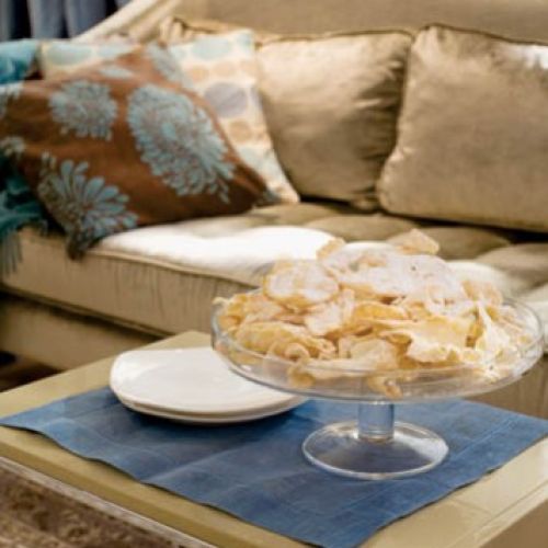 Beżowa kanapa przełamuje dominujące w tym salonie błękity.