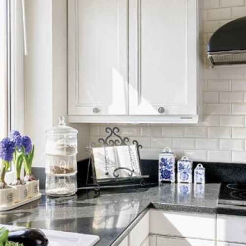 Biało-czarna, z czarnym kamieniem na blatach, symetryczna, do samego sufitu.