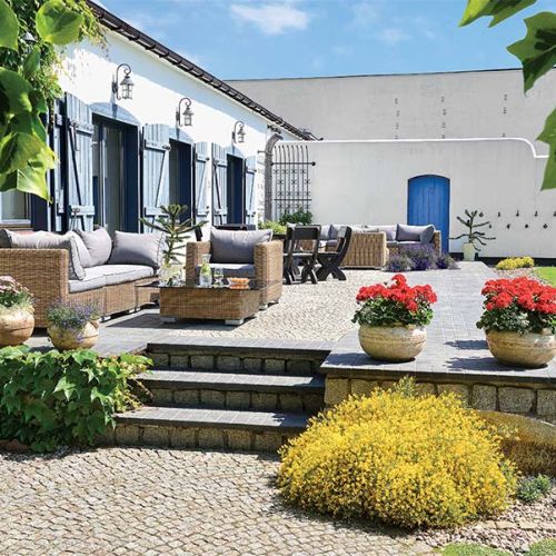 Bielone ściany pawilonu z błękitnymi okiennicami.