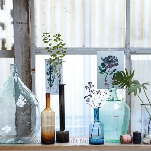 Butelki-flakony z kolorowego szkła będą efektowną dekoracją zarówno mieszkań w chłodnym stylu skandynawskim, jak i