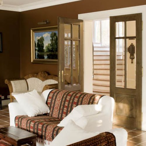 Ciemna podłoga i ściany oraz jasne kanapy nadają wnętrzu kontrastu.