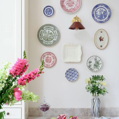 kolekcja porcelanowych talerzy na ścianie w kuchni
