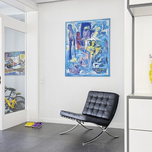 Ciepłym kolorom wnętrz przeciwstawia się eksplozja barw z wiszących na ścianach obrazów. Prawie wszystkie namalował