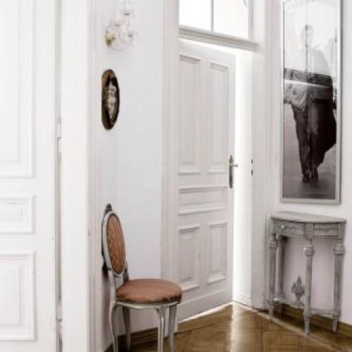 Czarno- białe portrety filmowych gwiazd zestawione z francuskimi, bogatymi meblami nadają wnętrzon lekkości.