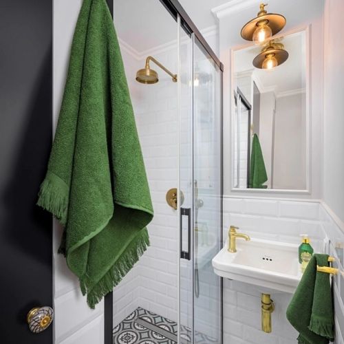 mała biała łazienka z czarnymi i złotymi dodatkami