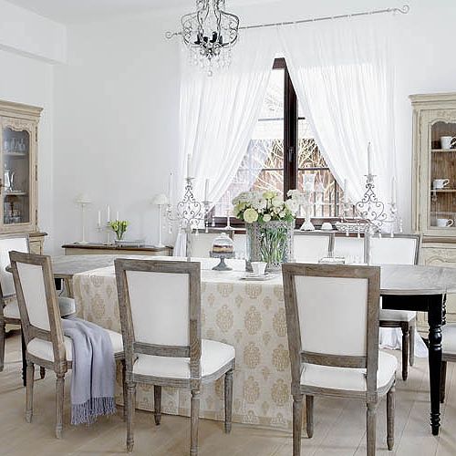 Część jadalna w stylu francuskim: duży stół i pięknie obite krzesła.