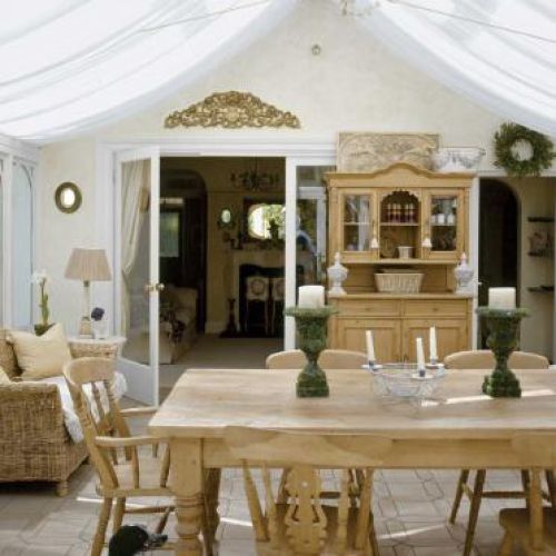 Do drewnianej, przeszklonej werandy najlepiej pasował solidny sosnowy kredens, stół i krzesła wygrzebane w sklepie